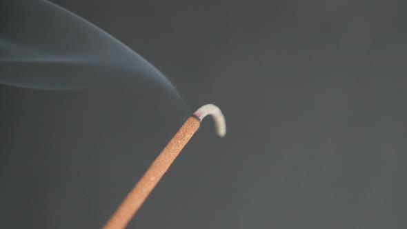 Close-up of fragrant smoke spreading from burned incense stick   4K 2160p 30fps UltraHD footage - Ar