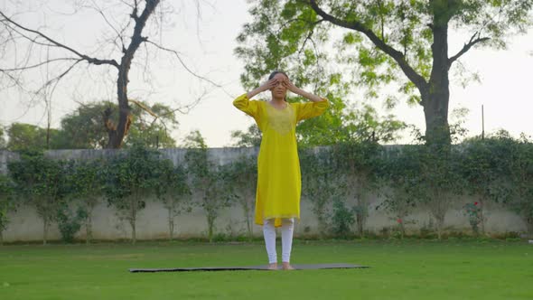 Indian man doing Bhramari Pranayama or the bee breath yoga pose in an Indian outfit