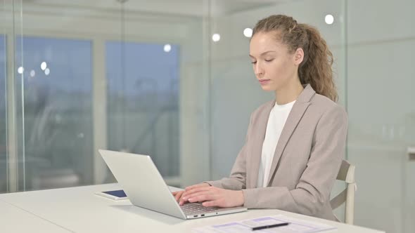 Ambitious Young Businesswoman Doing Thumbs Up in Office 