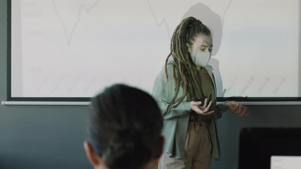 Female Manager in Face Mask Delivering Financial Presentation