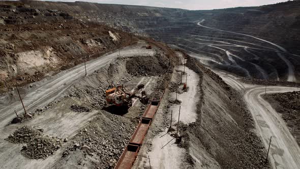 Excavator Loads Iron Ore Into a Freight Train