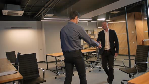 Two Businessman Shaking Hand to Each Other in Office