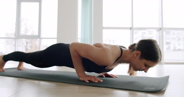 Athletic Beautiful Woman Does Pushups As Part of Cross Fitness Gym Training