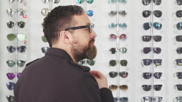 Mature Male Customer Choosing Glasses at the Eyewear Store