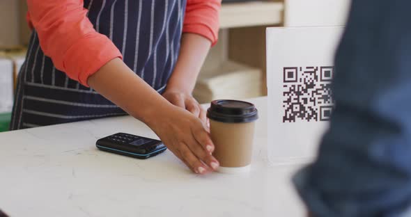 Video of hands of biracial waitress with payment terminal