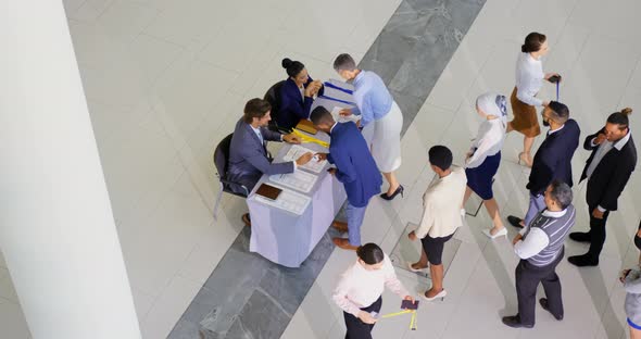 Business people checking in at conference registration table 4k