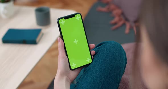 Backside View of Woman Holding and Looking at Smartphone Mock Up Screen. Female Person Using Phone