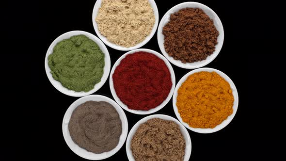 Various Spices and herbs on black background, rotate