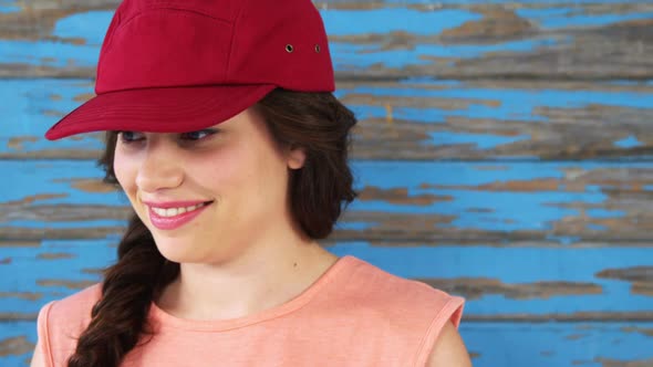 Fashionable woman standing against wooden background