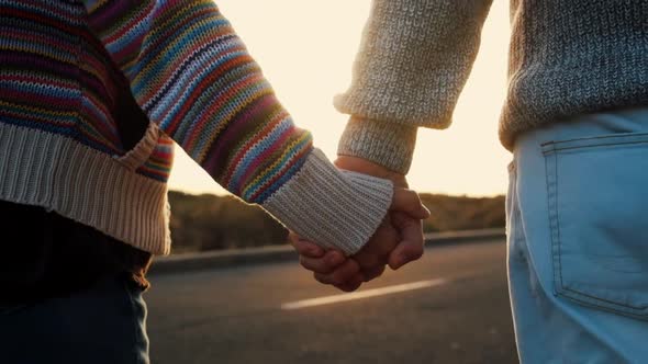 Adult mature couple walking holding hands with love and romance on a street with sunset