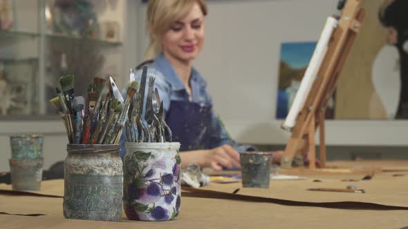 Selective Focus on a Bunch of Paintbrushes Female Artist Working on Her Painting