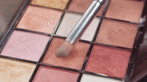 Close Up of Make Up Brush and Eyeshadows Palette on Vanity Table