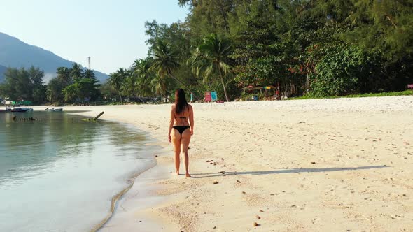 Beautiful women tanning on beautiful coast beach break by blue green lagoon and white sand backgroun