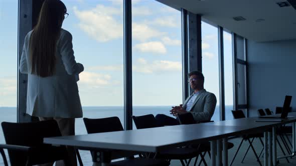 Secretary Giving Businessman Papers in Conference Hall