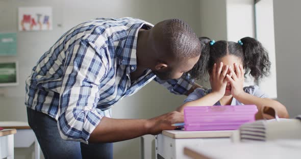 Video of african american male teacher supporting sad biracial girl