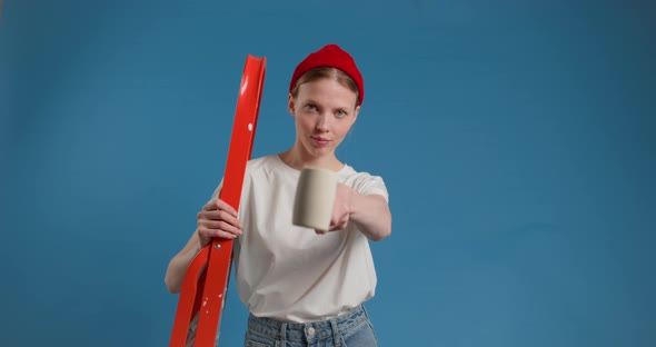 Young Woman with a Serious Face Shows Hammer to the Camera Laughs and Approvingly Shows Cool Gesture