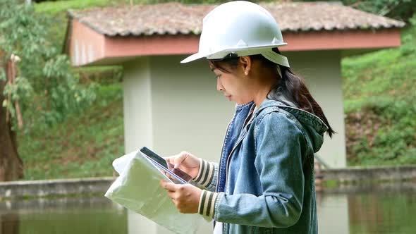 Female ecologist in safety hat working and controlling a quality of water