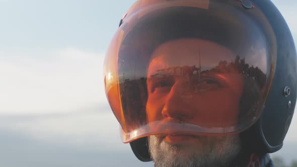 Portrait of Young Attractive Motorcyclist with Black Helmet on Street