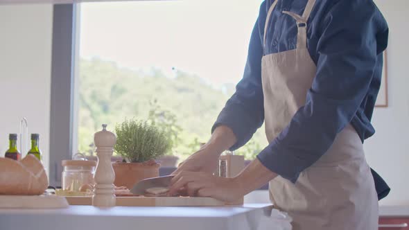 Detail of Man Hand Cutting Jowl Bacon with Knife