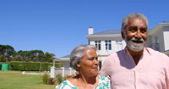 Front view of senior black couple walking together in garden on a sunny day 4k