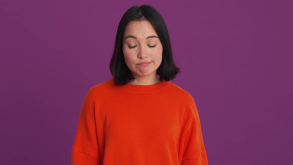 Displeased woman in red sweater showing blah blah gesture