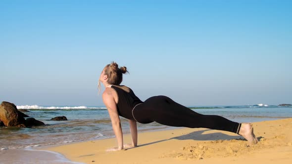 Barefoot Girl Relaxes After Yoga Exercises on Sandy Beach