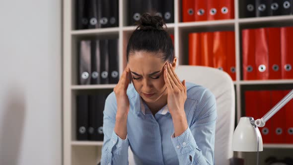 Portrait of Tired Young Businesswoman with Computer in Office