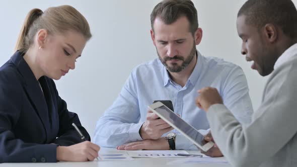 Business People Preparing Report While Using Smartphone and Tablet