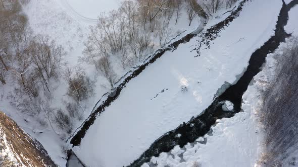 Frozen Bialka river and snowy forest in Poland. Aerial view