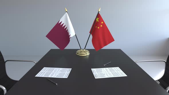 Flags of Qatar and China on the Table