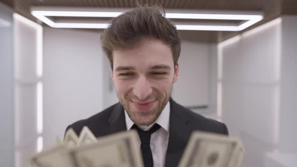 Closeup Portrait of Handsome Successful Rich Businessman Posing with Cash Money in Office Indoors