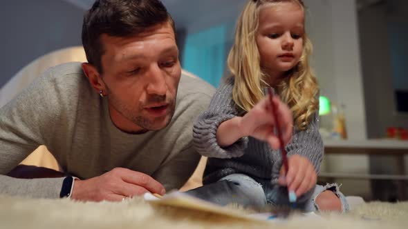 Cute Little Daughter Painting in Living Room As Handsome Father Talking Endorsing Child