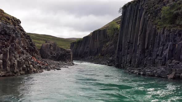 Drone Rising Over River In Studlagil Canyon