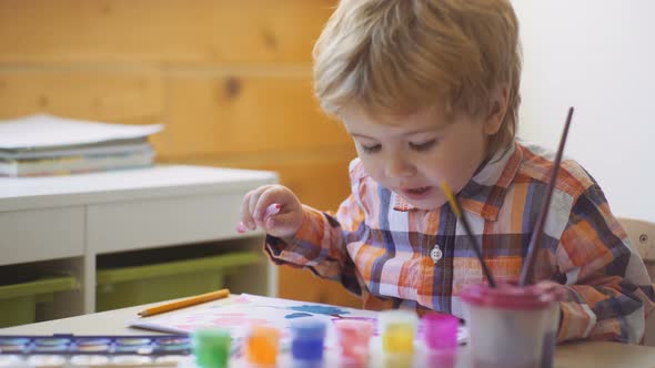 Happy Cute Boy Colors His Hands. Doing Finger Painting. Art Therapy for Children. Psychology of the