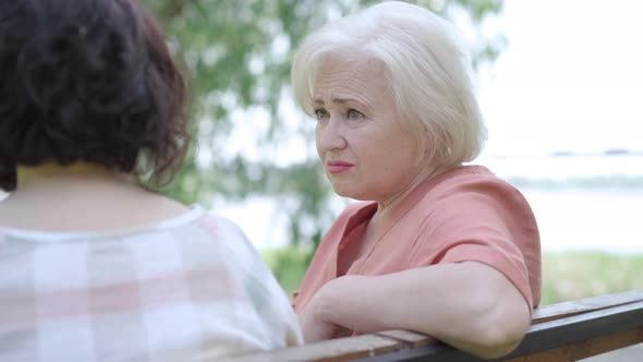 Attentive Caring Senior Woman Listening To Unrecognizable Girlfriend and Shaking Head. Portrait of