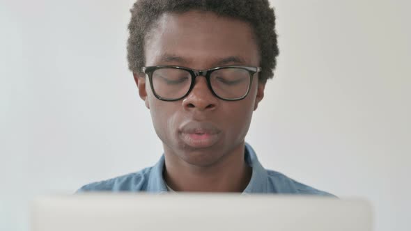 Close Up of Young African Man Reacting to Loss While Using Laptop