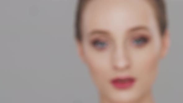 Studio portrait of young, beautiful and natural woman over grey background.