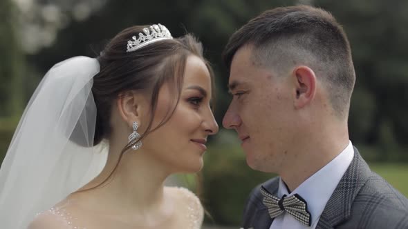 Newlyweds. Caucasian Groom with Bride Walking, Embracing, Hugs in Park. Wedding Couple