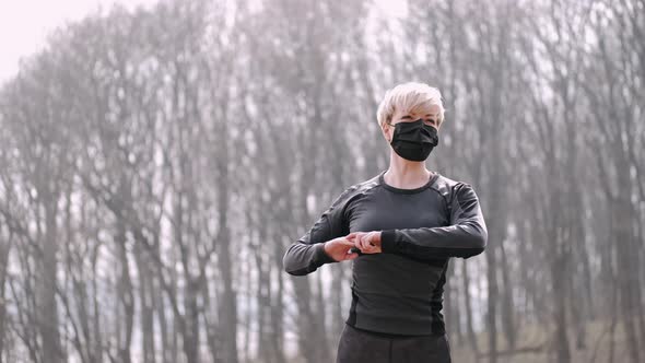 A Middle-aged Woman in a Mask Is Doing Morning Exercise Outside