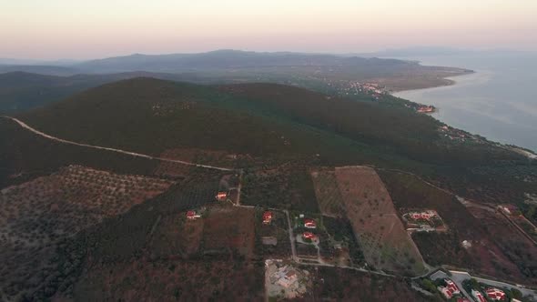 Flying Over Green Landscape with Plains and Hills in Coastal Town, Greece
