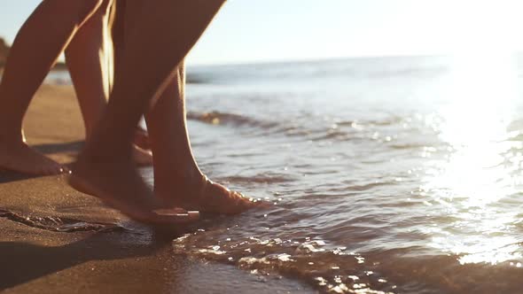 Close Up View of Friends' Legs at Seaside Touching Water