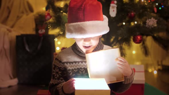 Portrait Ofexcited Boy in Santa Hat Opens Christmas Present Box and Looks Inside