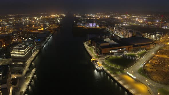 Aerial flyover of Belfast City Centre and Lagan River at night