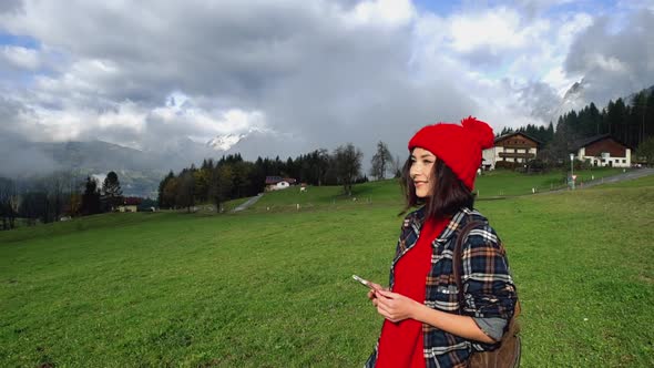 Pretty Smiling Asian Woman Girl Hiking Equipment Walk in Mountain Alps Looks Around Take Photo on