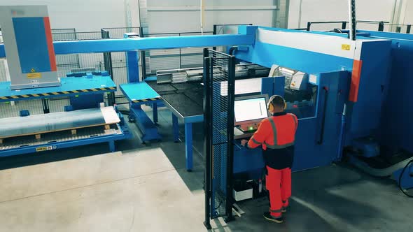 Male Technician Is Operating a Large Cutting Machine