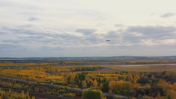 Aerial View of Airliner Taking Off From Airport Over the Autumn Forest