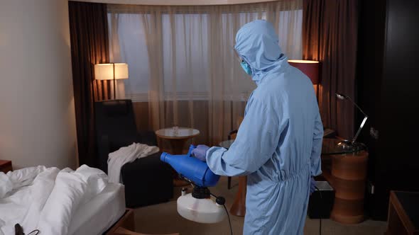 Disinfection Specialist Spraying Bed in Hotel Room