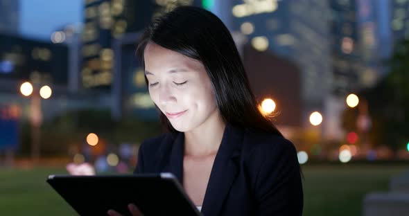 Business woman use of tablet computer at night