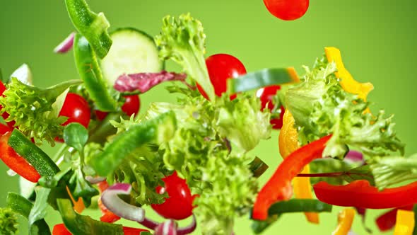 Super Slow Motion Shot of Flying Fresh Vegetables on Green Gradient Background at 1000Fps