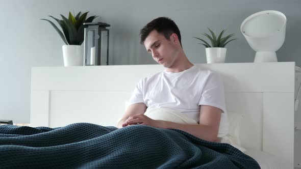 Man Sitting and Sleeping in Bed